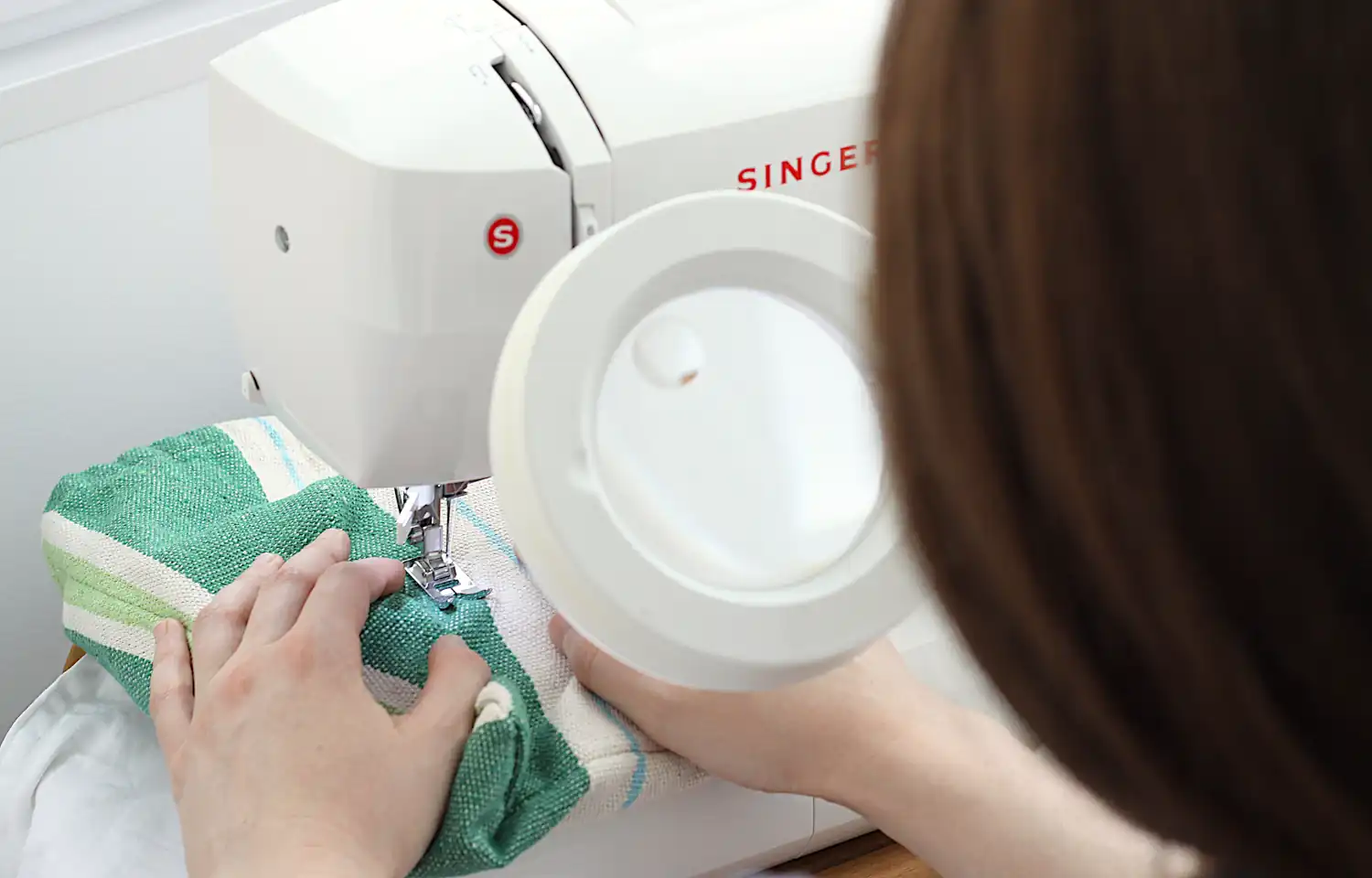 sewing with the help of a magnifying lamp